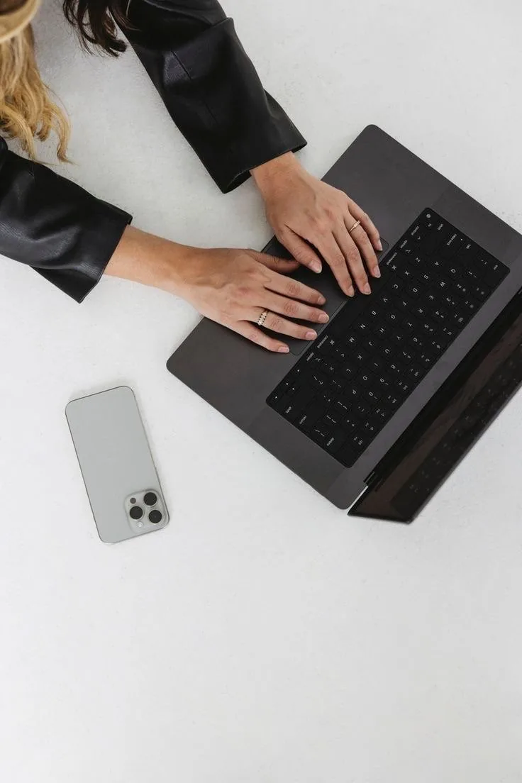 Hands typing on a laptop